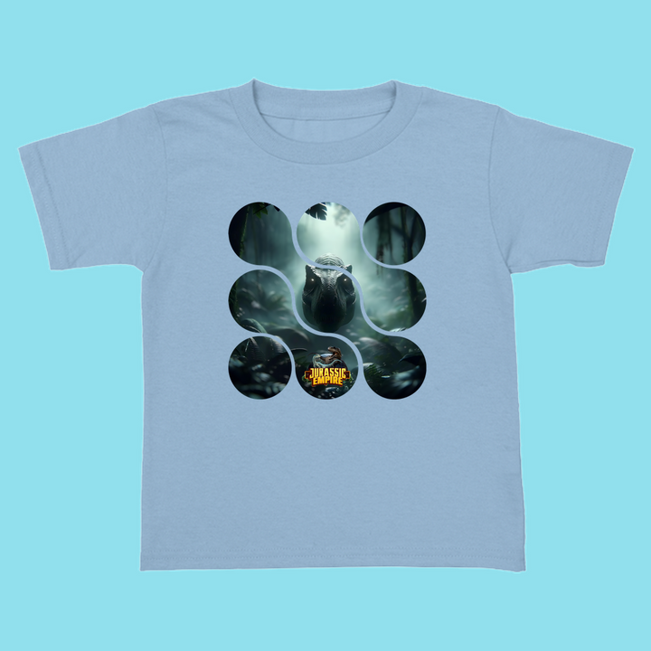 The Toddler Jurassic Empire T-Rex T-Shirt by Jurassic Studio features a dinosaur in a misty forest through circular cutouts, plus the Jurassic World logo—a perfect gift for dino fans and a true Jurassic Studio exclusive.