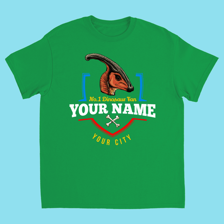 The Jurassic Studio N.1 Hadrosaur Fan Custom Kids T-shirt features a Parasaurolophus head, No.1 Dinosaur Fan text, bone graphics, and your child’s name and city on a light blue shirt—an ideal personalized dinosaur gift.