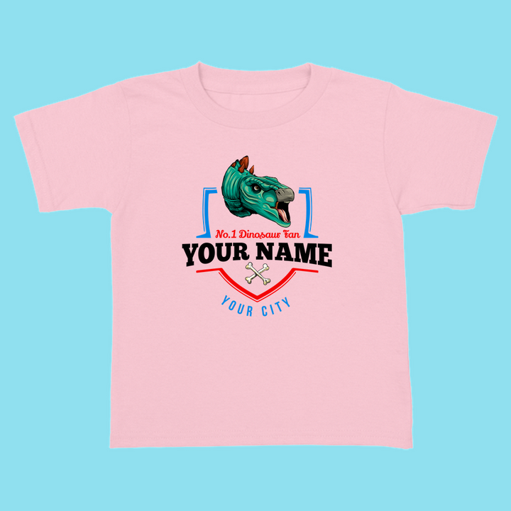 The N.1 Stegosaurus Fan Custom Toddler T-Shirt by Jurassic Studio features a cartoon dino head with No. 1 Dinosaur Fan and your custom name, plus crossed bones on light blue—an adorable personalized dinosaur gift!.