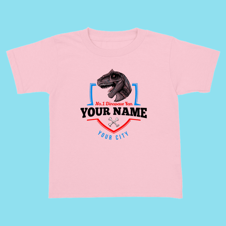 The N.1 Allosaurus Fan Custom Toddler T-Shirt by Jurassic Studio features a pink dino head and “No.1 Dinosaur Fan, Your Name, Your City” on blue, plus a wrench icon. Perfect personalized shirt for little dinosaur lovers!.