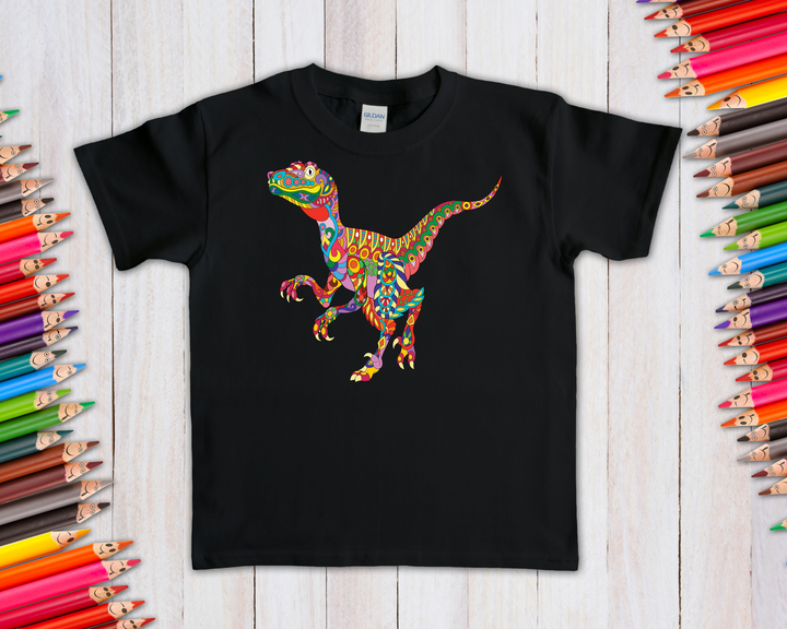 The black Kids Velociraptor Zentangle T-Shirt by Jurassic Studio features a colorful dinosaur design, shown on a wooden surface with colored pencils—an exclusive, perfect gift for young dinosaur fans.