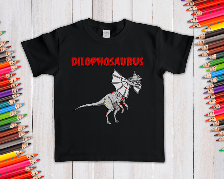 The Kids Robot Dilophosaurus T-Shirt by Jurassic Studio features a black tee with a cartoon robot dinosaur and bold red text—an exclusive gift for dino fans. Shown on wood, surrounded by colored pencils.
