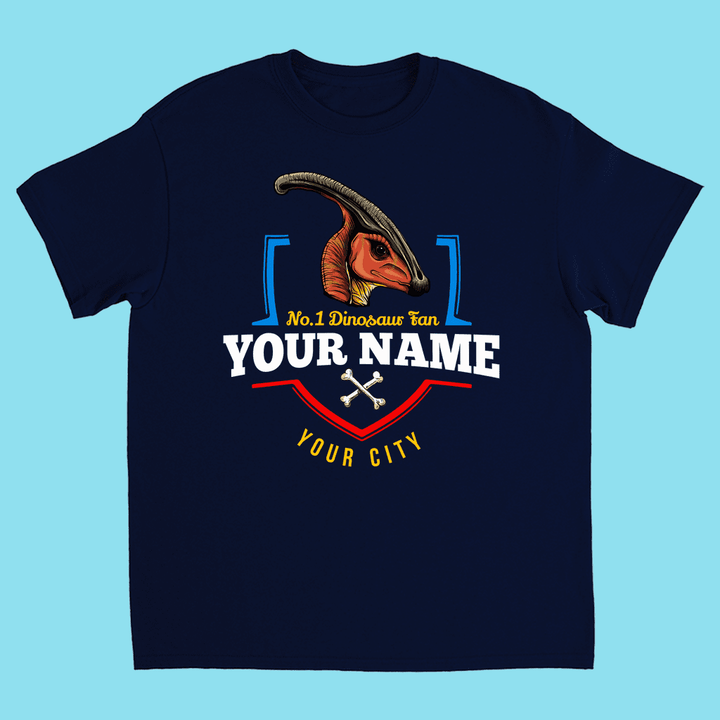 Jurassic Studios N.1 Hadrosaur Fan Custom Kids T-shirt features a parasaurolophus graphic above “No.1 Dinosaur Fan,” YOUR NAME, YOUR CITY, and two white crossed bones on light blue—perfect for dino-loving kids!.