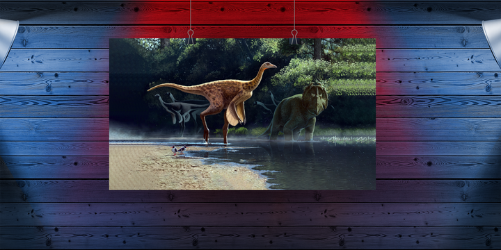 The Rativates Poster by Jurassic Studio features dinosaurs by a riverbank under soft sunlight. Framed and displayed on a blue and red wooden wall, this artwork adds prehistoric charm to any room.