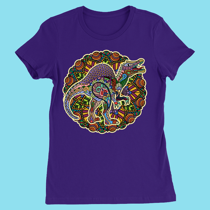 The Women Spinosaurus Mandala T-Shirt by Jurassic Studio features a vibrant dinosaur design with tribal mandala patterns on a bold purple tee—perfect for dino fans and available exclusively from Jurassic Studio.