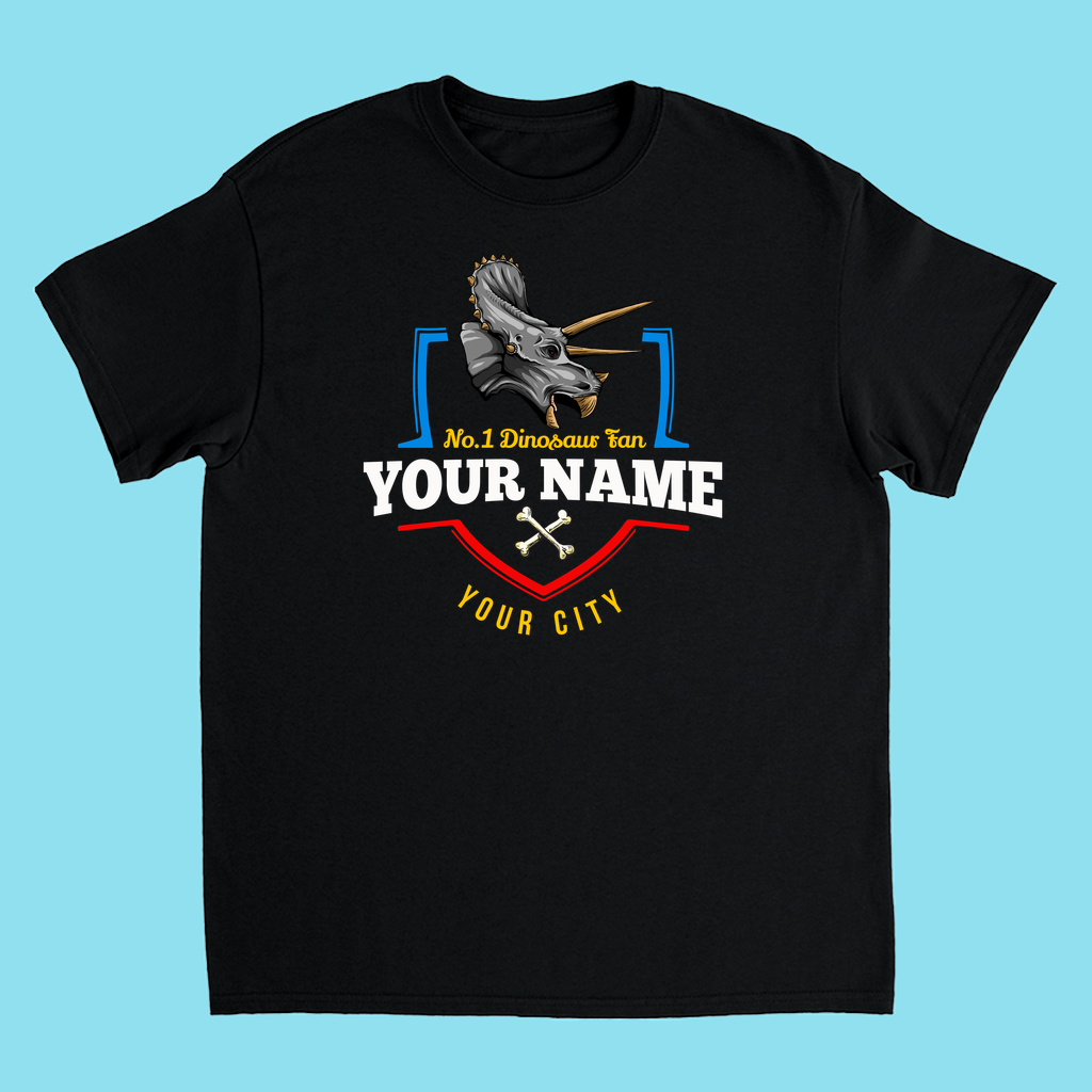 The N.1 Triceratops Fan Custom Kids T-Shirt by Jurassic Studio features a triceratops graphic above N.1 Dinosaur Fan, your name, and city, with crossed bones and colorful accents—a fun personalized gift for kids who love dinosaurs! Light blue background included.