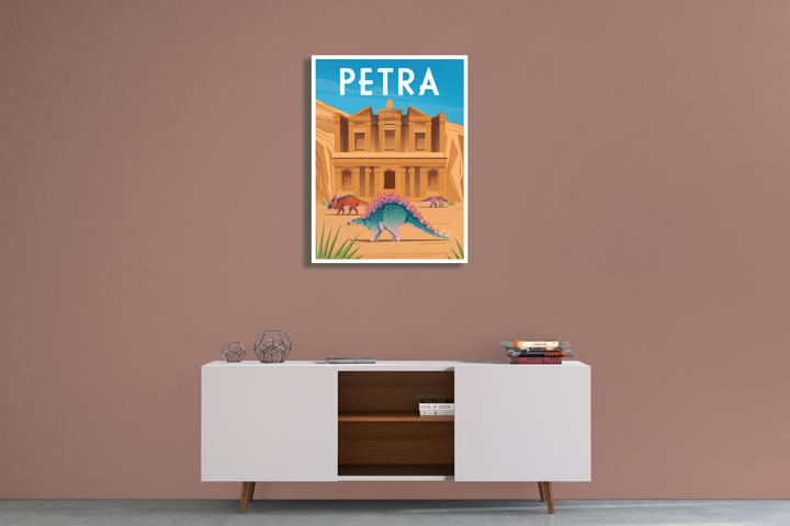 A modern room with a mauve wall, white cabinet, and a Jurassic Studio Petra Canvas Wrap above it, featuring the famous rock-cut facade, camels, and whimsical dinosaur artwork in the foreground.