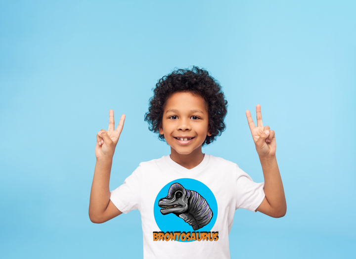 A boy raises his hands, showing off his Kids Brontosaurus Head T-Shirt by Jurassic Studio—the perfect gift for young dinosaur fans.