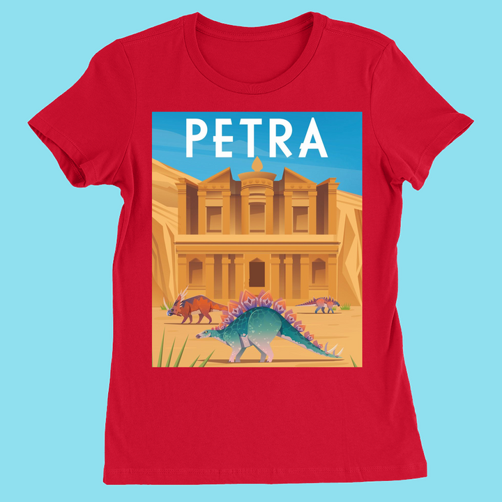 The Women Petra T-Shirt by Jurassic Studio is a red slim fit tee with PETRA in bold white letters and an illustrated Petra facade, three colorful dinosaurs, and a blue sky. This womens dinosaur shirt is a Jurassic Studio exclusive.
