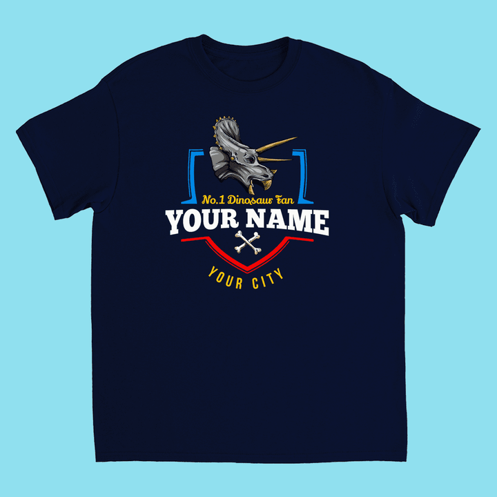 The N.1 Triceratops Fan Custom Kids T-Shirt by Jurassic Studio features a triceratops graphic, No.1 Dinosaur Fan text, and personalized name and city—an ideal kids dinosaur gift set on a light blue background.