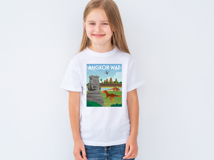 A smiling girl wears the Kids Angkor Wat T-Shirt by Jurassic Studio, showing a stone face, trees, a bird in the sky, and a rooster. ANGKOR WAT tops this charming design inspired by Jurassic Studio.