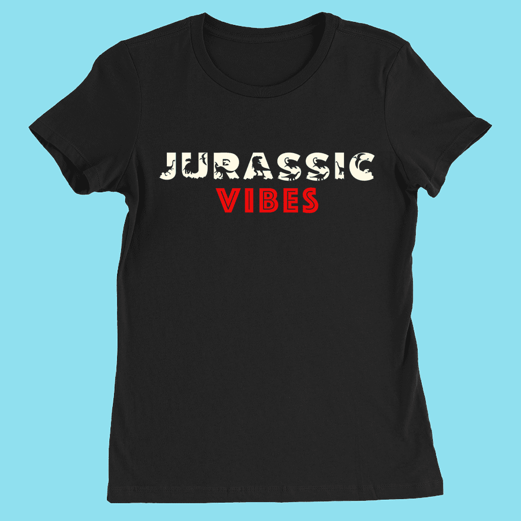 The Women Jurassic Vibes T-Shirt by Jurassic Studio features JURASSIC in white with dinosaur silhouettes and VIBES in bold red on the front. This trendy slim fit tee is shown on a light blue background.
