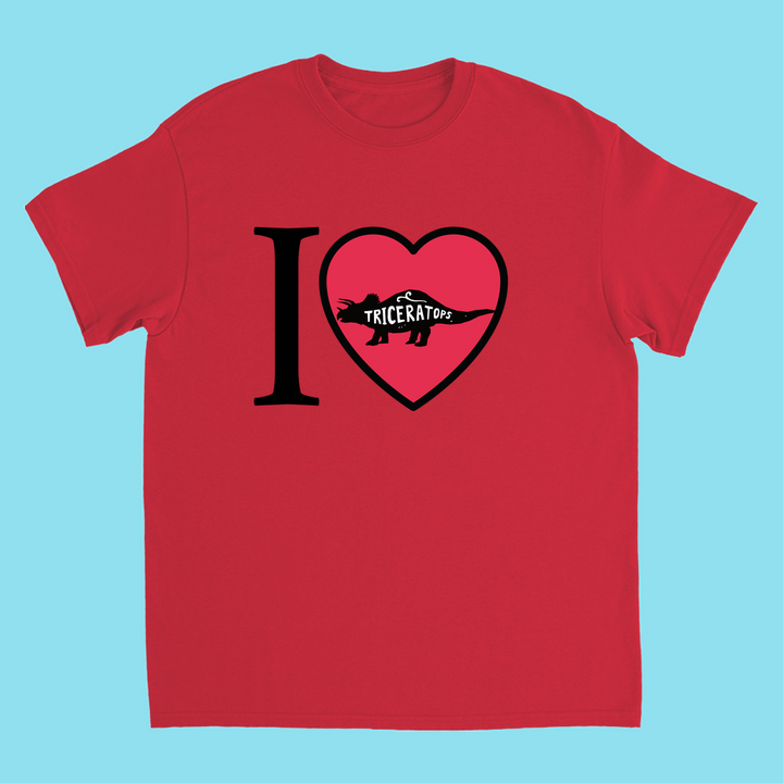 The Kids I Love Triceratops T-Shirt by Jurassic Studio features “I ♥ Triceratops” text with a dino silhouette in the heart, on a red shirt with light blue background. Perfect gift for young dinosaur fans.