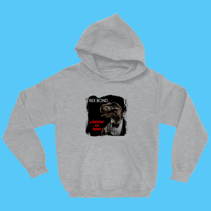 The Kids Rex Bond Hoodie by Jurassic Studio features a dapper dinosaur in a tuxedo, styled like James Bond, with Rex Bond and License to Roar in red—perfect for any young dinosaur fan!.