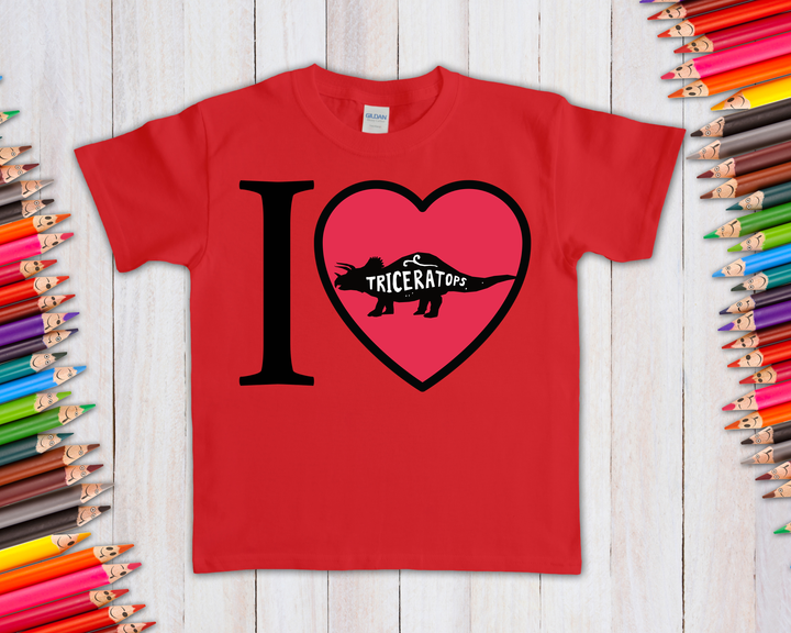 The Kids I love Triceratops T-Shirt by Jurassic Studio features a red design with I ♥ Triceratops in black and a triceratops silhouette. A perfect dinosaur fan gift and a Jurassic Studio exclusive!.