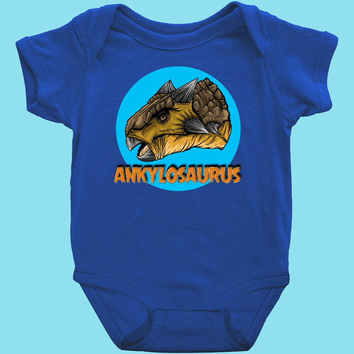 Jurassic Studio’s Toddler Ankylosaurus Head Onesie features a cute blue Ankylosaurus cartoon in a blue circle above bold orange “ANKYLOSAURUS” text. A Jurassic Studio exclusive!.