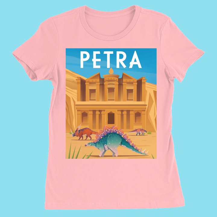 The Women Petra T-Shirt by Jurassic Studio is a pink slim fit tee with Petra’s iconic rock-cut architecture, stegosaurus and triceratops under a blue sky, PETRA at the top. A unique women’s dinosaur t-shirt.