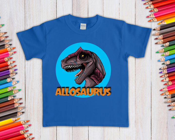 The Kids Allosaurus Head T-Shirt by Jurassic Studio features a cartoon Allosaurus head with an open mouth on a blue shirt, set in a light blue circle with ALLOSAURUS in bold orange—an exclusive gift for dinosaur fans!.