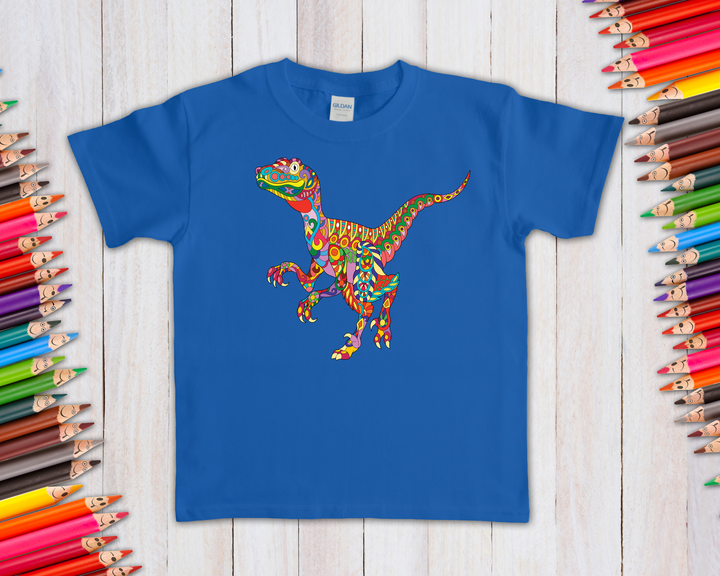 The Kids Velociraptor Zentangle T-Shirt by Jurassic Studio features a vibrant, patterned dinosaur graphic—an ideal gift for dino fans. Displayed flat on light wood and surrounded by colored pencils, it’s a fun and exclusive design.