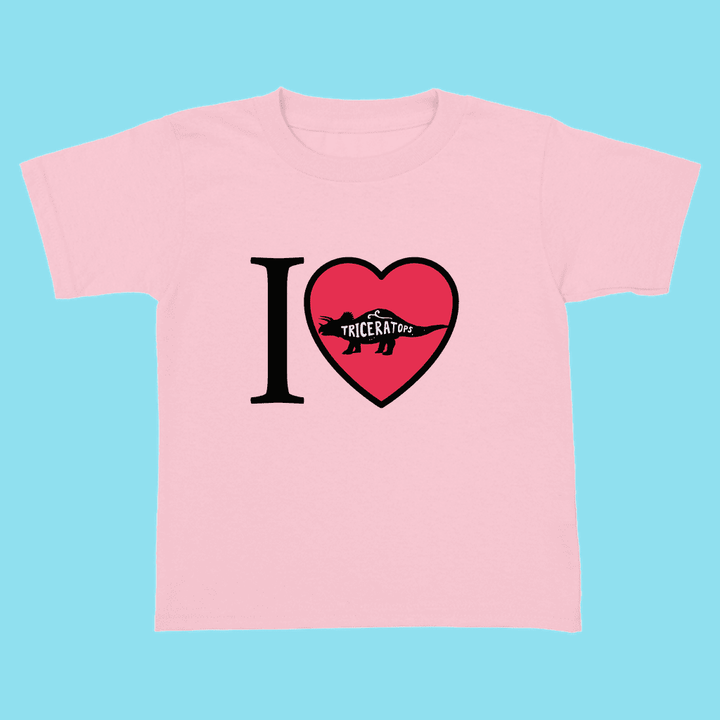 The Jurassic Studio Toddler I Love Triceratops T-Shirt features a pink design with “I ♥ Triceratops” on the front. The heart includes a triceratops silhouette, making it an adorable choice for any little dinosaur fan.