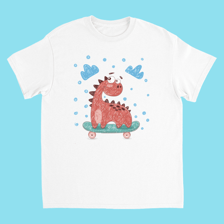 The Jurassic Studio Kids Baby Dino Skate T-Shirt features a playful red dinosaur on a skateboard, surrounded by blue clouds and bubbles, set against a light blue background.