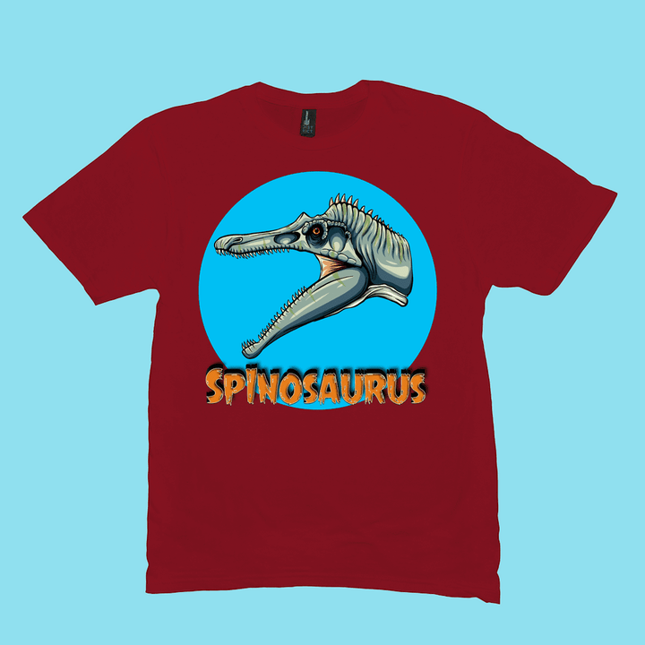 The Men Spinosaurus Head T-Shirt by Jurassic Studio features a cartoon red Spinosaurus in a blue circle with bold yellow SPINOSAURUS below—perfect for dinosaur fans and available exclusively from Jurassic Studio.