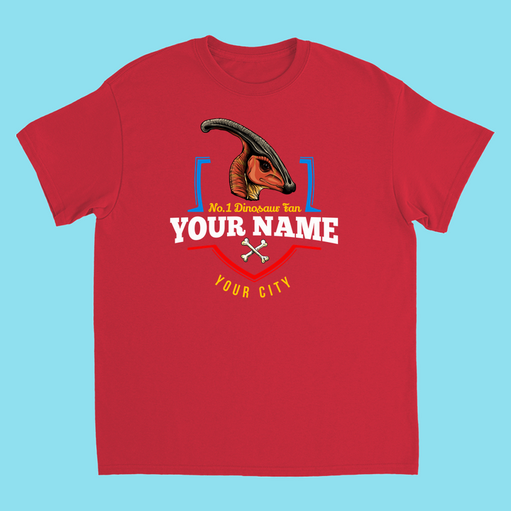 The N.1 Hadrosaur Fan Custom Kids T-shirt by Jurassic Studio features a red shirt with an illustrated parasaurolophus, blue brackets, crossed bones, and customizable text for Your Name and City—perfect as a personalized kids dinosaur gift on light blue.
