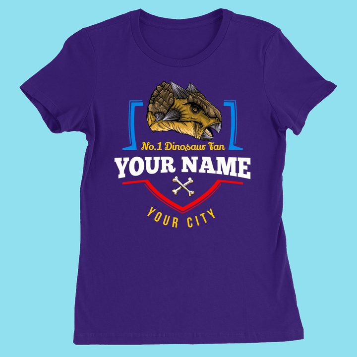 Purple women’s N.1 Ankylosaurus Fan custom T-shirt by Jurassic Studio features a brown ankylosaurus, your name and city, and two white crossed bones—a fun personalized dino shirt on a blue background.