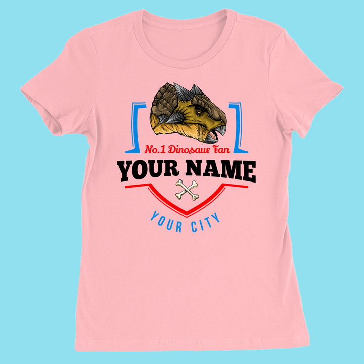 Jurassic Studios light blue womens t-shirt features an Ankylosaurus above N.1 Dinosaur Fan, with your name and city, plus two crossed dinosaur bones for a fun, personalized touch.