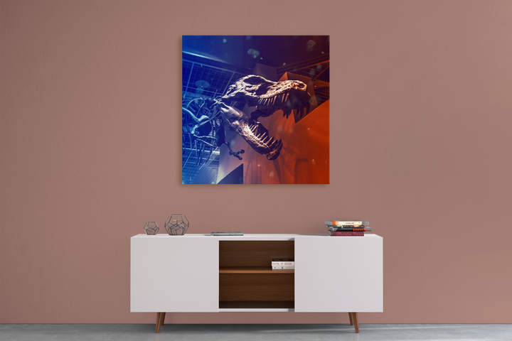 A modern sideboard with books and decor stands against a mauve wall, topped by the T-Rex Skeleton Canvas Wrap from Jurassic Studio—a striking framed dinosaur skull with dramatic blue and red lighting.