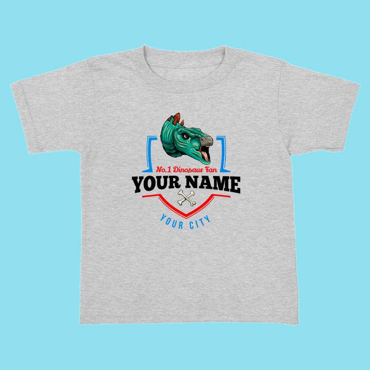 Jurassic Studio’s gray N.1 Stegosaurus Fan Custom Toddler T-Shirt features a cartoon dino head, “No. 1 Dinosaur Fan YOUR NAME YOUR CITY,” and crossed bones on the front—a fun personalized dinosaur gift for kids.