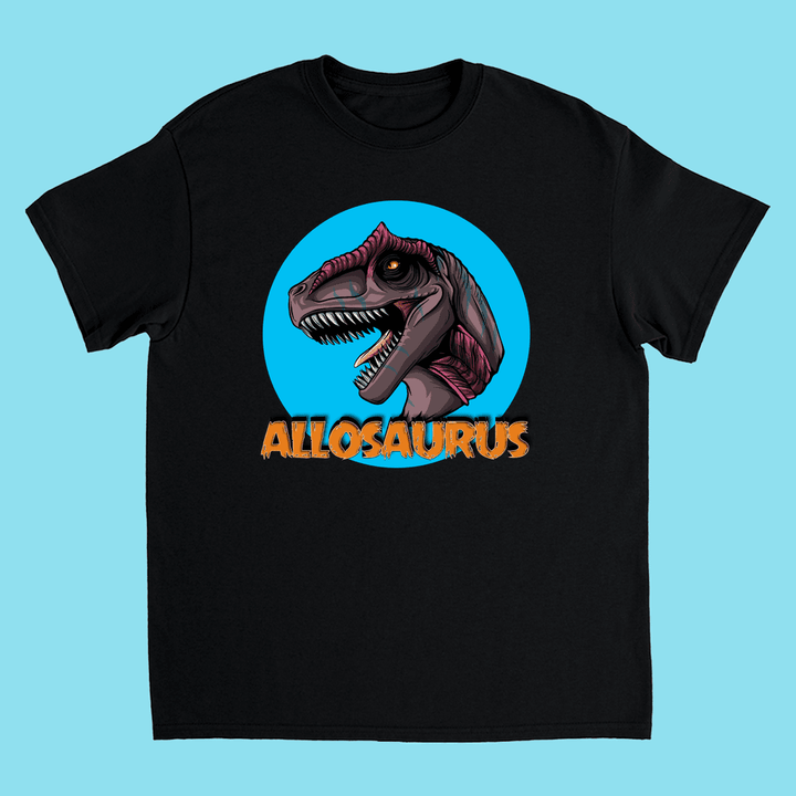 The Kids Allosaurus Head T-Shirt by Jurassic Studio features a cartoon Allosaurus head in a blue circle, ALLOSAURUS in bold orange below, and a light blue background—perfect for dinosaur fans.