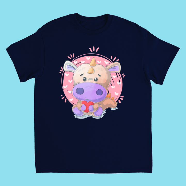 Jurassic Studios Kids Pink Baby Dino T-Shirt features a cute cartoon dinosaur with a pink circle and tiny hearts on a light blue background.