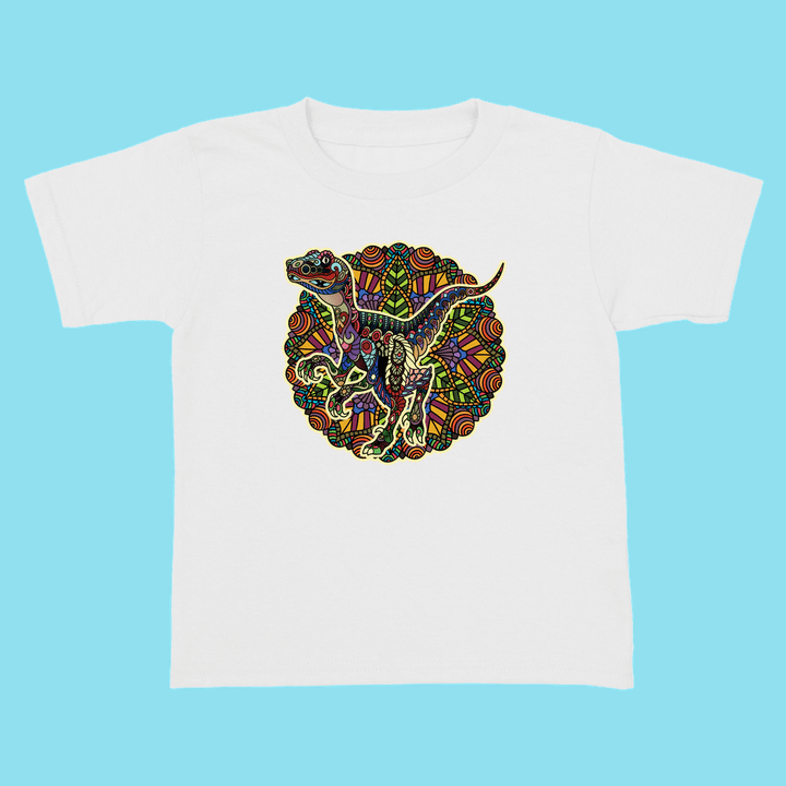 The Jurassic Studio Toddler Velociraptor Mandala T-Shirt features a colorful circular dinosaur design on a white tee with a light blue background—an exclusive, perfect gift for young dinosaur fans.