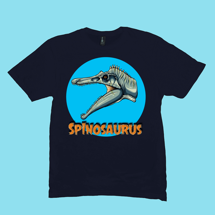 The Jurassic Studio Men Spinosaurus Head T-Shirt features a cartoon Spinosaurus head in a blue circle with bold orange SPINOSAURUS below—an ideal gift for dinosaur fans.