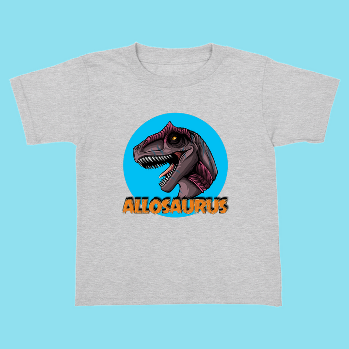 The Jurassic Studio Toddler Allosaurus Head T-Shirt features a vibrant Allosaurus illustration inside a blue circle with bold orange lettering—an ideal dinosaur fan gift.