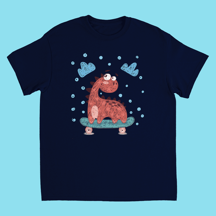 The Kids Baby Dino Skate T-Shirt by Jurassic Studio features a navy blue design with a cute red cartoon dino on a skateboard, surrounded by blue clouds and dots—perfect for little ones who love dinos and skating!.