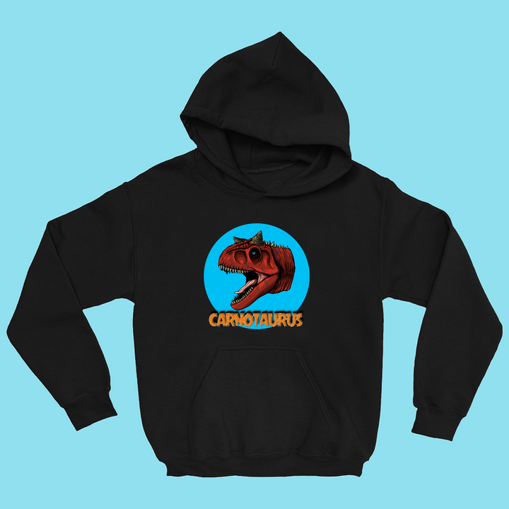 The Jurassic Studio Kids Carnotaurus Head Hoodie features a roaring red Carnotaurus in a blue circle with bold orange CARNOTAURUS below, all set on a light blue background.