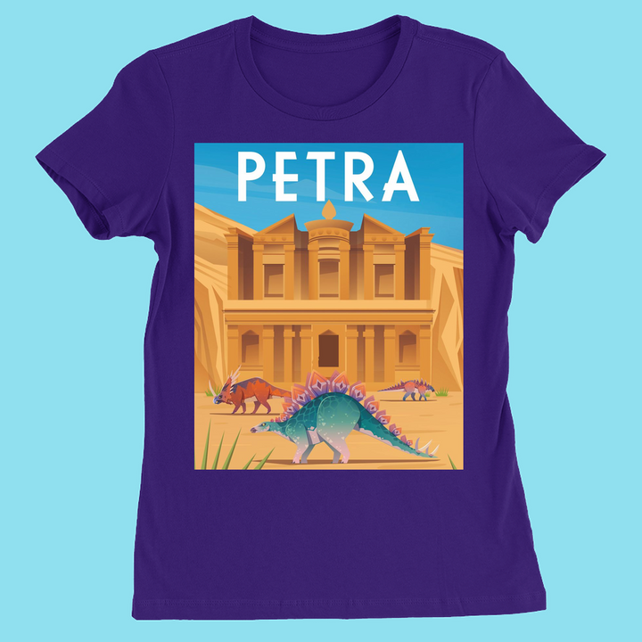 The Women Petra T-Shirt by Jurassic Studio is a purple slim fit tee with an illustrated design of Petra’s stone facade, dinosaurs like a stegosaurus, and bold “PETRA” text—available exclusively from Jurassic Studio.