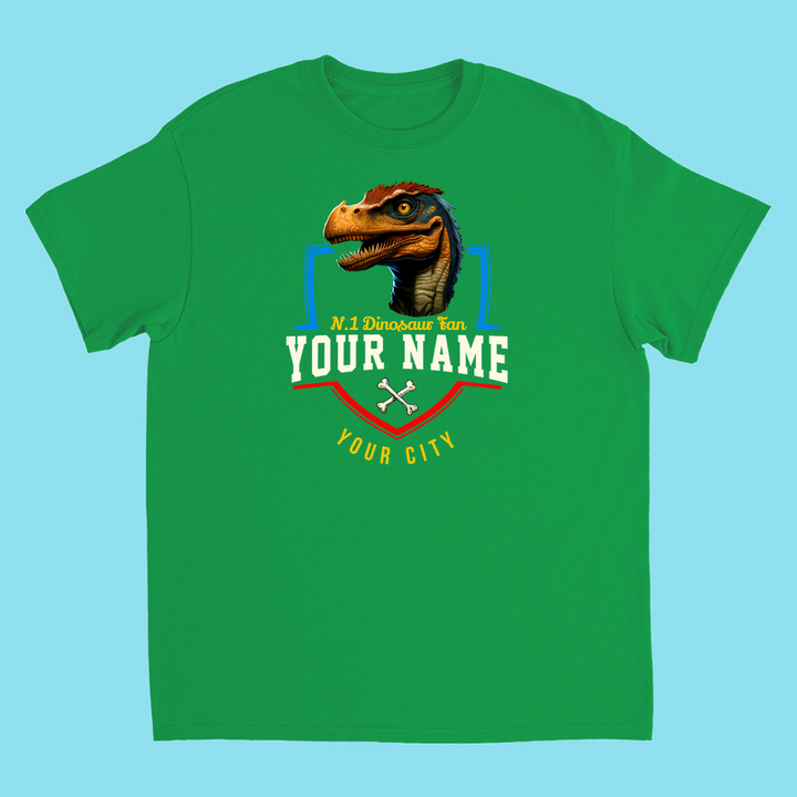 The N.1 Velociraptor Fan Custom Kids T-Shirt by Jurassic Studio features a green tee with a dinosaur head graphic and your personalized name and city above “No. 1 Dinosaur Fan”—a perfect, customizable gift for kids who love dinosaurs. Background is light blue.