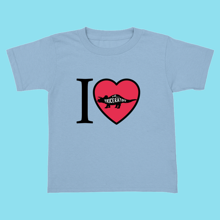 The Jurassic Studio Toddler I Love Triceratops T-Shirt is a light blue tee featuring “I ♥ Triceratops,” with a red dinosaur silhouette and “Triceratops” inside the heart—a cute dinosaur shirt for little fans.
