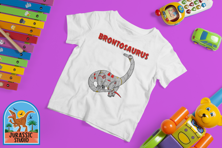 A Jurassic Studio exclusive, the Toddler Robot Brontosaurus T-Shirt shows a cartoon dino with bold red lettering and colorful toys on a purple background—an ideal gift for little dinosaur fans.