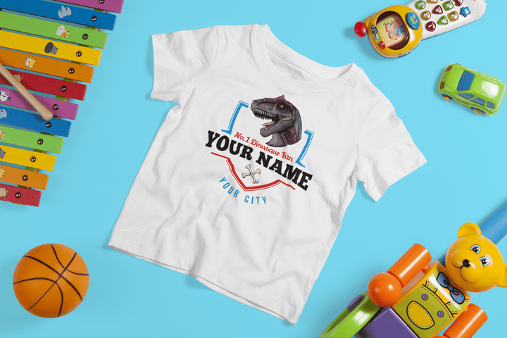 The N.1 Allosaurus Fan Custom Toddler T-Shirt by Jurassic Studio is a white personalized dinosaur shirt for kids with a fun dino graphic and custom text, displayed among colorful toys on a bright blue background.